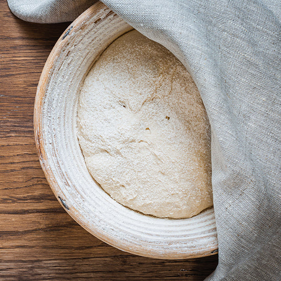 Dough fermenting in bowl covered by cloth